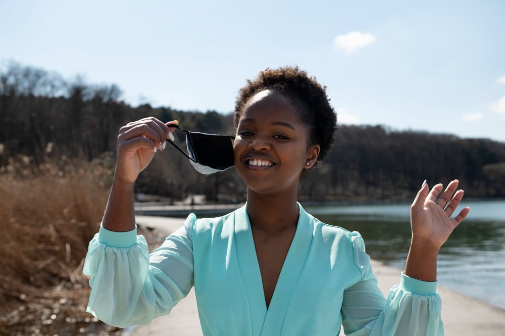 Young woman celebrating the lifting of face mask restrictions outdoors in the city (Freepik.com)